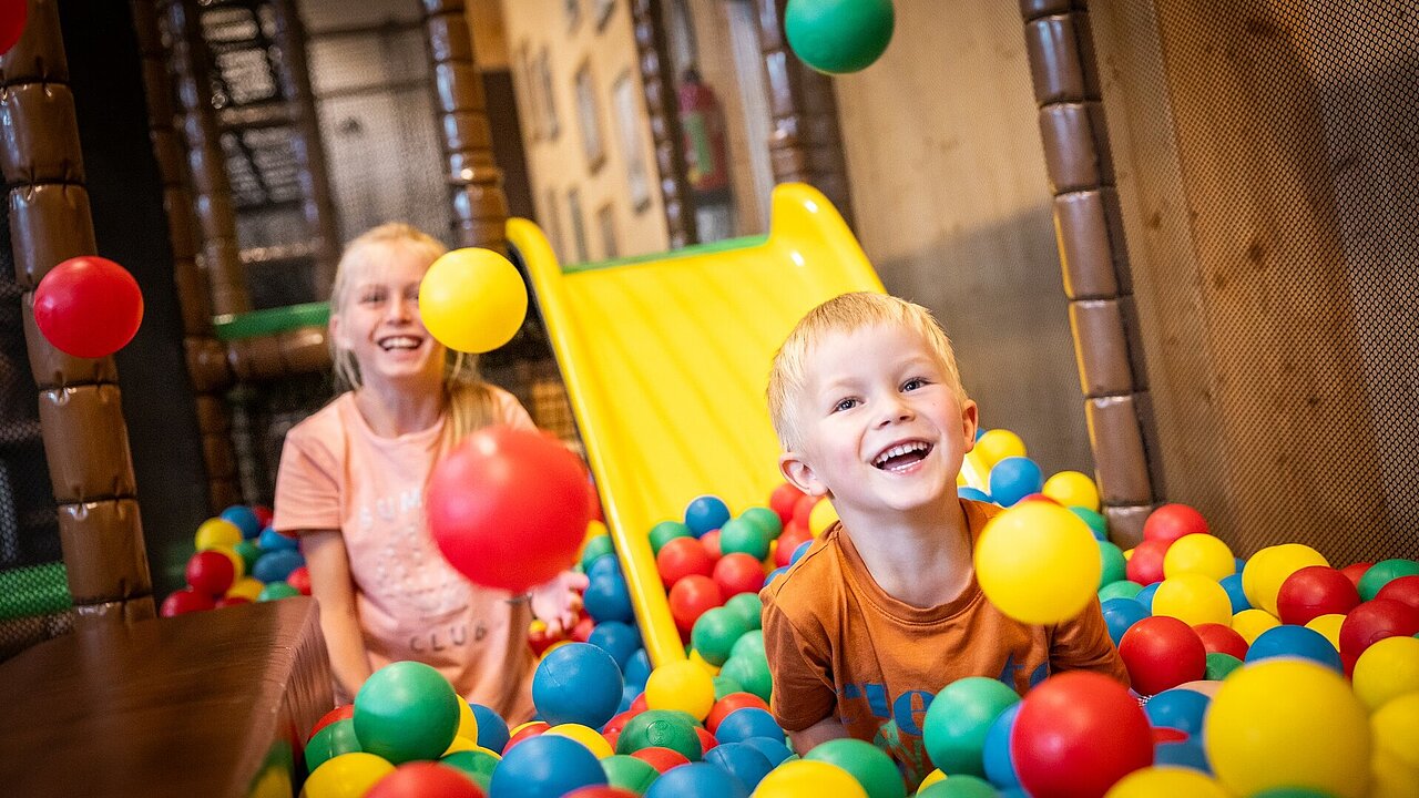 Zwei Kinder spielen im Bällebad der Indoor-Spielscheune im Elldus Resort