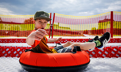 Ein Teenager rodelt lässig und cool die neue Tubingbahn im Elldus Resort herunter!